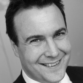 Smiling person in a suit, black and white photo.