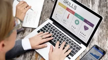 Personne travaillant sur un ordinateur portable avec un tableau d'évaluation des compétences à l'écran.