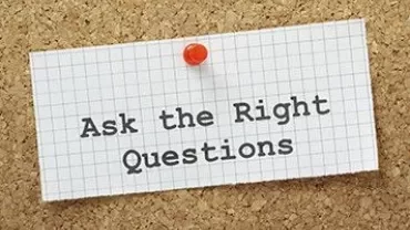 Message sur un tableau en liège : 'Ask the Right Questions'.