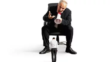 Personne sur une chaise criant dans un mégaphone à un individu plus petit.