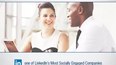 Two people having a discussion at a table with a tablet, LinkedIn award mentioned.