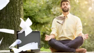 Personne méditant en plein air avec des papiers volants.