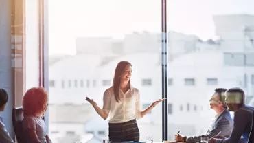 Person leading a meeting in a sunny office.