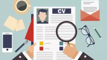 Hands holding a CV with magnifying glass, coffee, and laptop.