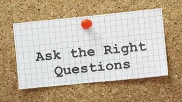 Corkboard with note reading 'Ask the Right Questions'.