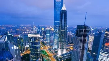 City skyline at night with tall illuminated buildings.