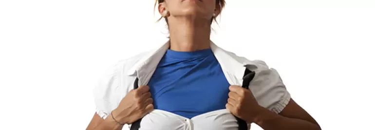 Une personne portant des lunettes ouvre une chemise blanche pour révéler une chemise bleue.