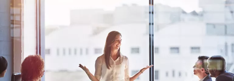 Person leading a meeting in a sunny office.
