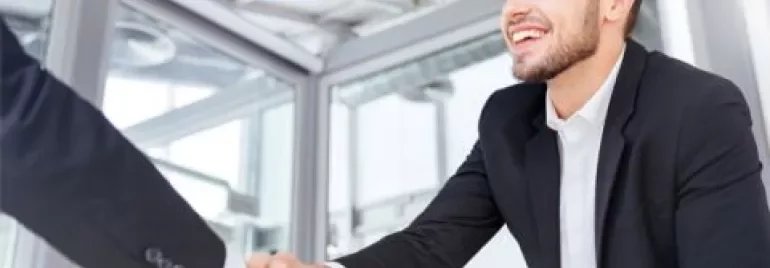 Personne d'affaires souriante serrant la main dans un bureau.
