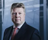 Person in a suit in a modern office setting.