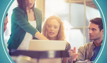 Group working together at a desk with a laptop.