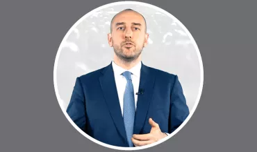 Person in a suit giving a speech.