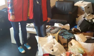Two people with collection bags in a room.